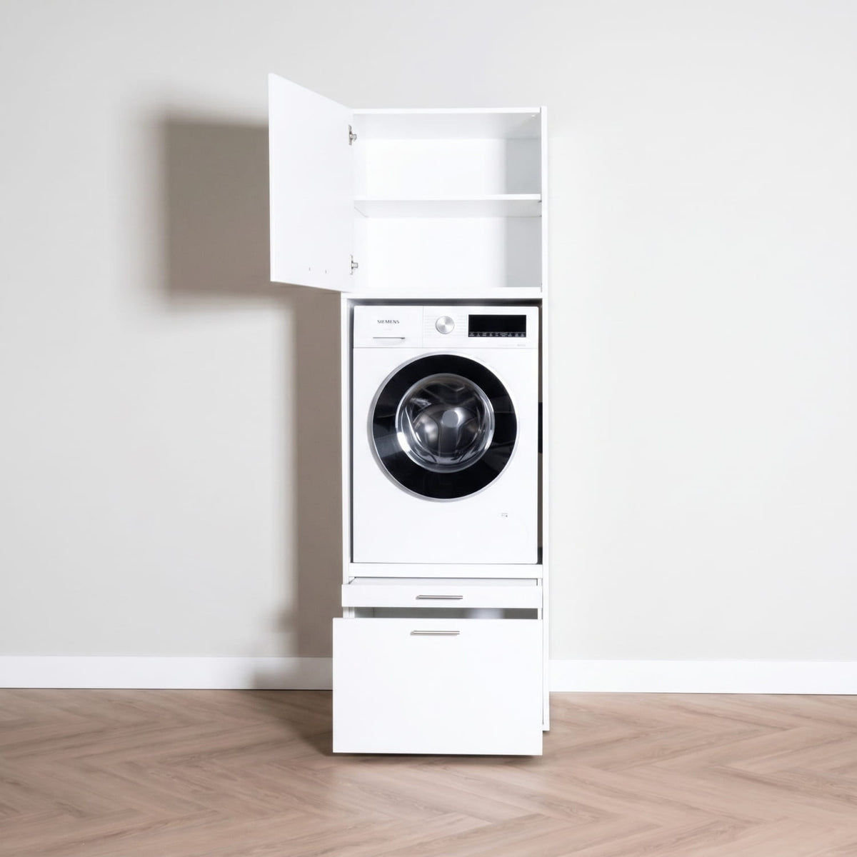 White tall laundry cabinet with open top door, front-loading washing machine inside, and bottom drawer on parquet floor.