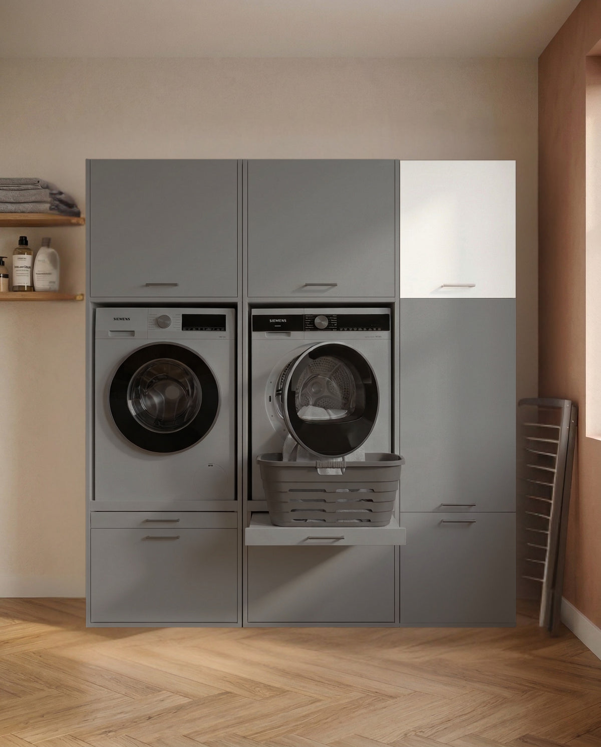 Gray and white built-in laundry storage cabinet with front-loading washer and dryer and pull-out laundry basket in modern.